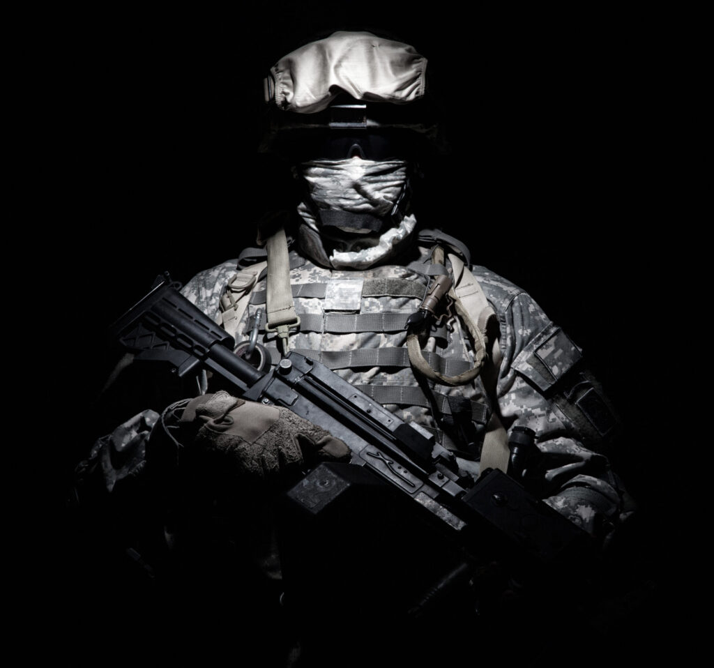 Ένοπλος στρατιώτης στέκεται στο σκοτάδι
