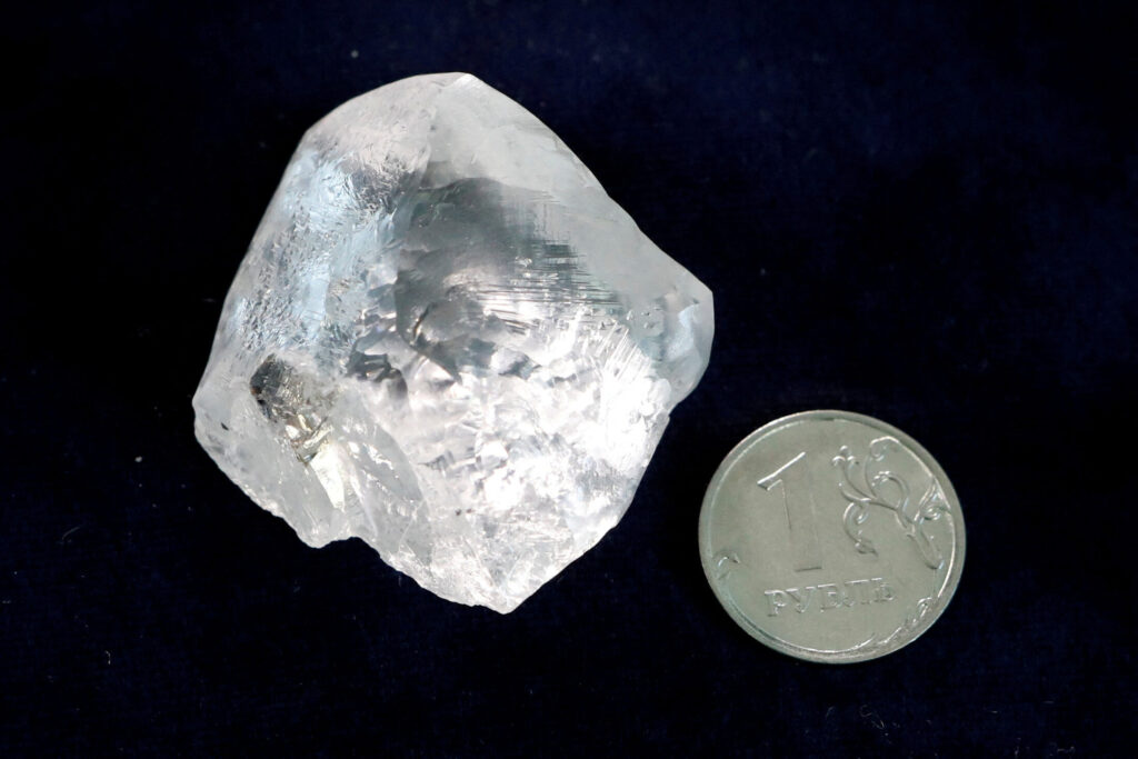 Ένα ακατέργαστο διαμάντι δίπλα σε ένα κέρμα 1 ρουβλίου